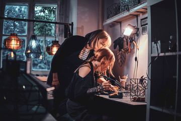 Expirienced master and her new assistant are working together doing new lamp.