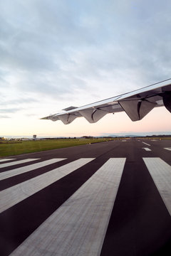 Wing of a small plane and regional airport runway before take off