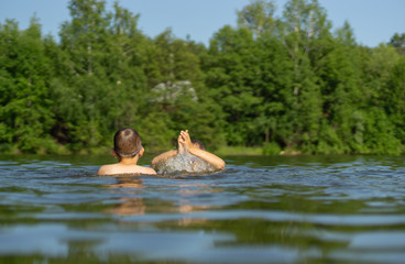 Fototapeta na wymiar two teenage boys swim in the lake