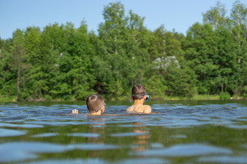 two teenagers swim in the lake