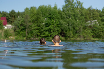 two teenagers swim in the lake