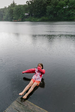 Girl Falling Backwards off of Dock in Rainstorm