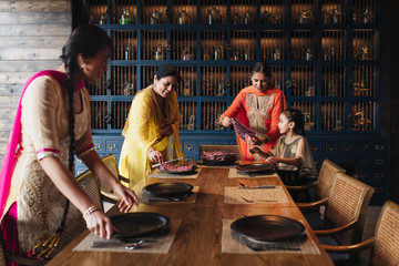 Family Setting Up Dinner Table