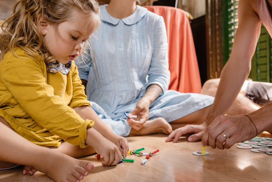 Crop parents with girl on floor playing