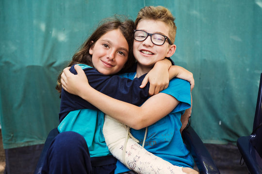 Sister embrace her brother with broken arm