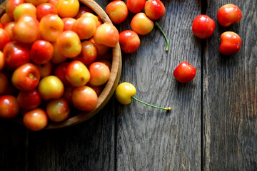 Sweet cherry in a wooden bowl on a wooden table.