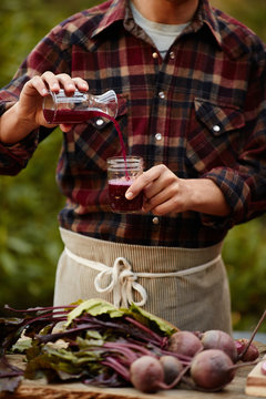 Man making homemade fermented probiotic beet kvass drink