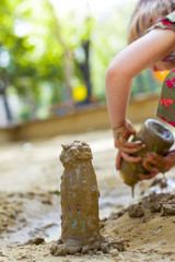 Kleines Kind spielt mit Matsch und Sand. little Child playing with mud pies and sand.
