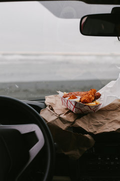 eating fish and chips to go in car on the beach