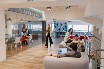 Group of people having a meeting in the modern office, woman using a mobile phone