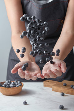Midsection of woman tossing blueberries