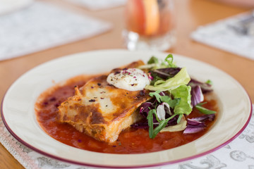 Tasty delicious italian dish lasagna with tomato sauce and cream cheese with green salat. Food, tasty dinner concept