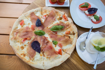 Italian pizza with jamon, basil, cheese and tomato. Food concept