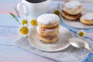 Curd cheesecakes on a white plate sprinkled with powdered sugar. Delicious dessert.