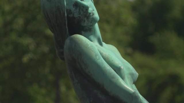 Beautiful female statue in luscious garden