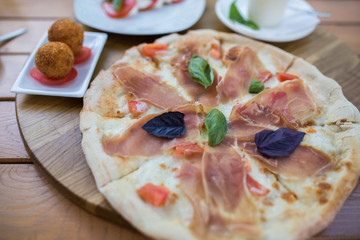 Italian pizza with jamon, basil, cheese and tomato. Food concept