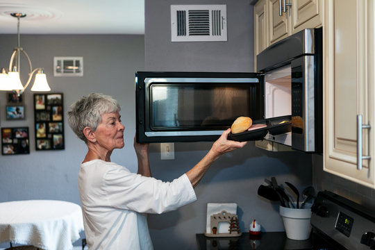 Meal: Woman Puts Delivered Meal Into Microwave To Warm