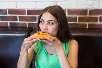 Hungry Russian girl  eats a piece of pizza relish