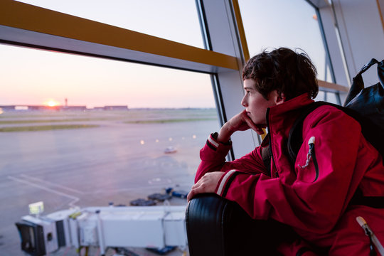 Teenage boy in an airport terminal waiting to board a flight