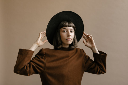 Fototapeta Studio portrait of young woman in vintage clothing and hat