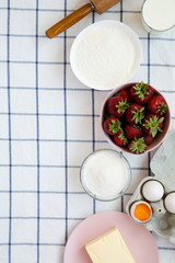 Top view, strawberry pie ingredients (flour, eggs, butter, milk, sugar, strawberry). Cooking strawberry pie or cake. Copy space.
