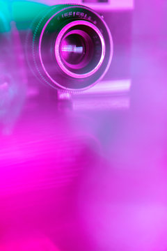 Old retro camera under colorful neon lights