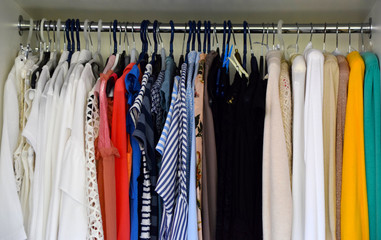 Clothes and blouses on hangers in the wardrobe