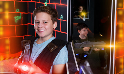 boy aiming laser gun at other players during lasertag game