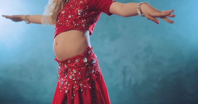 Belly dance. Oriental dance in a bright costume. Movement hips. Close-up.