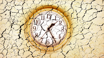 grunge style conceptual image of close up clock face on dried and cracked landscape