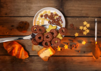 Spoon full of cereals and milk over breakfast table