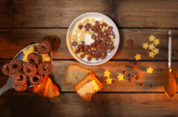 Spoon full of cereals and milk over breakfast table