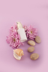 Skin care cosmetics bottle. Flowers pink background