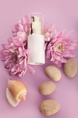 Obraz na płótnie Canvas Skin care cosmetics bottle. Flowers pink background