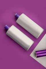 cosmetics shampoo bottles, tubes. Modern flat lay still life bundle on colorful frosted background. Skin or hair care.