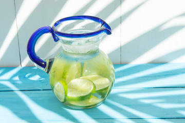Lime water in glass jar on colorful background