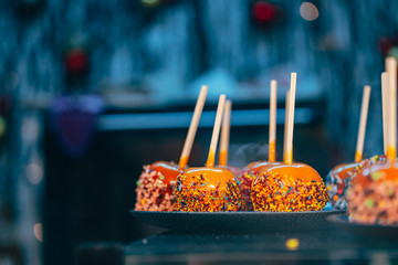 Apples in caramel and sprinkles. Street food.