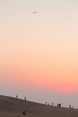 Obraz na płótnie Canvas 砂漠の夕日に浮かぶ飛行機