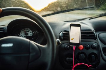 travel driving a car in the summer, the navigator in the smartphone. the driver is driving