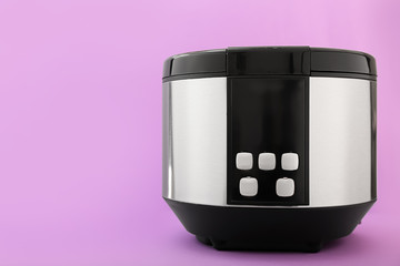 Modern multi cooker on color background