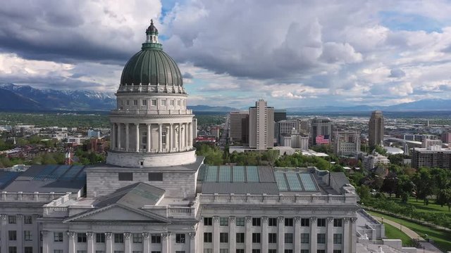 Aerial view of downtown Salt Lake City while flying past the Capitol building moving past the dome.