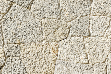 Texture of old grey stone wall with cracks close up