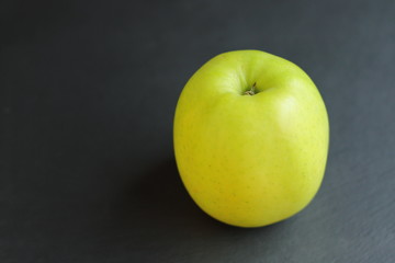fresh raw ripe apple on black slate table background, place for text