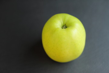 fresh raw ripe apple on black slate table background, place for text