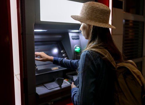 Woman using ATM on street