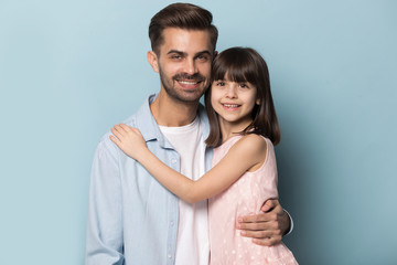 European appearance father and little daughter embracing studio shot