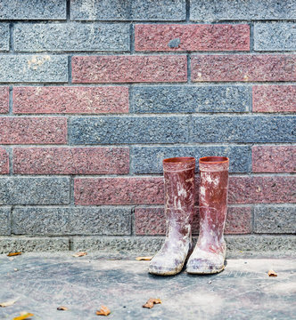 Muddy rain boots in corner after working in farm