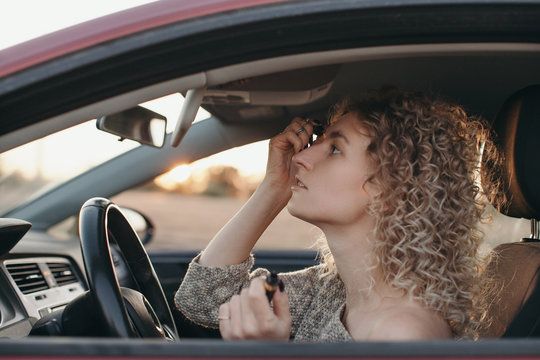 Woman driver applying makeup