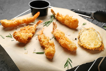 Cooling rack with tasty shrimps on dark background