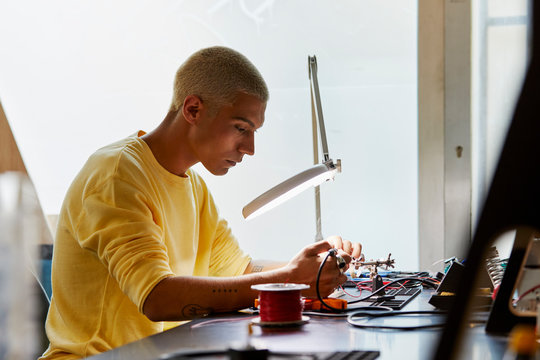 Engineer Working On Electronic Equipment At Desk